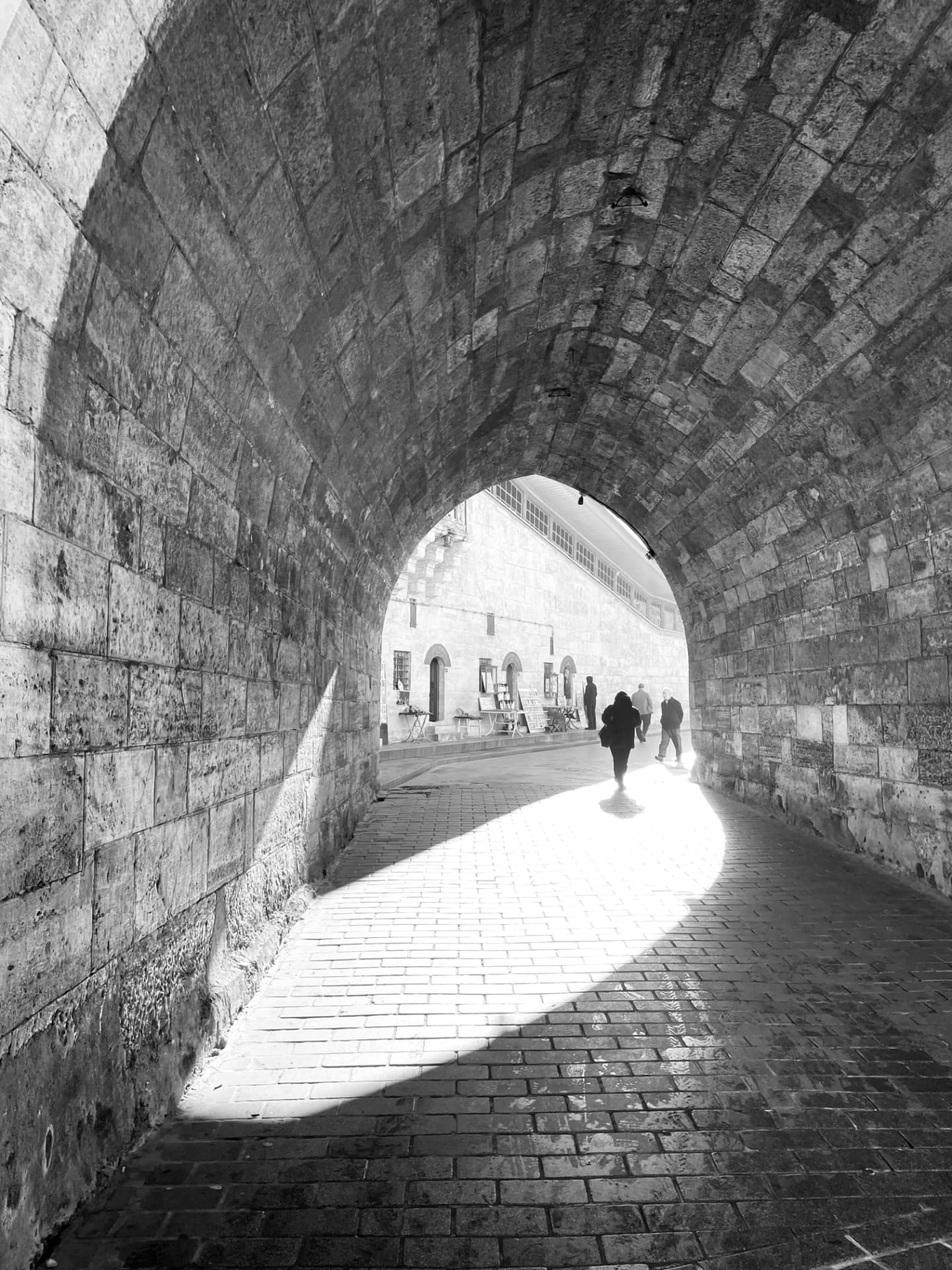 Black and white stone archway opening into bright daylight