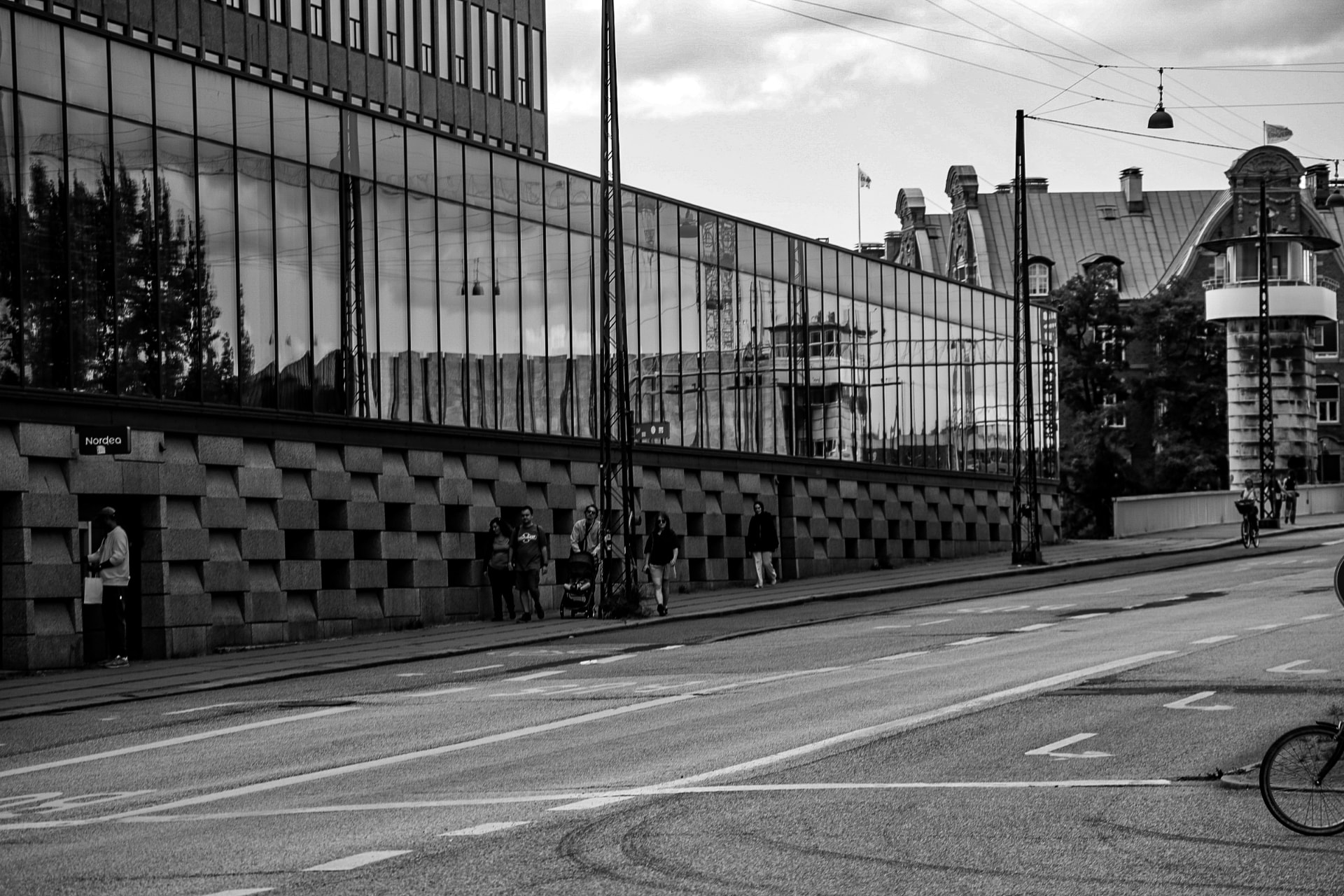Black and white street scene beside curved glass architecture