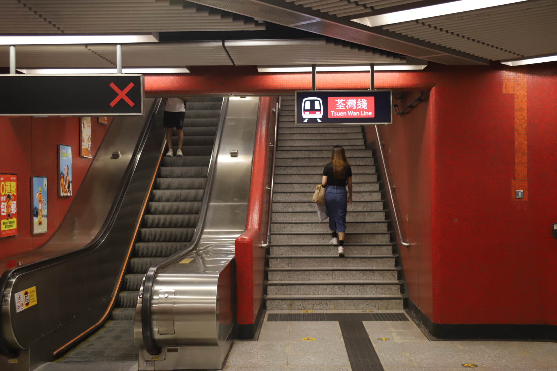 Red tiled underground station with stairs and escalator